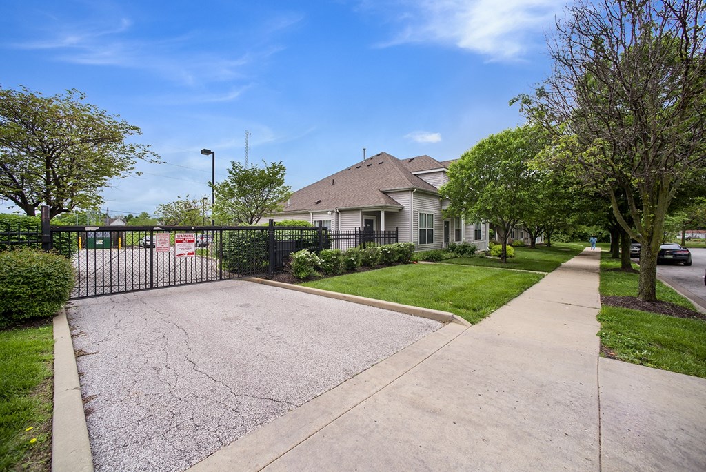 the view of a house with a driveway and a fence