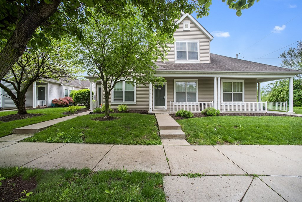 a house with a sidewalk and trees in front of it