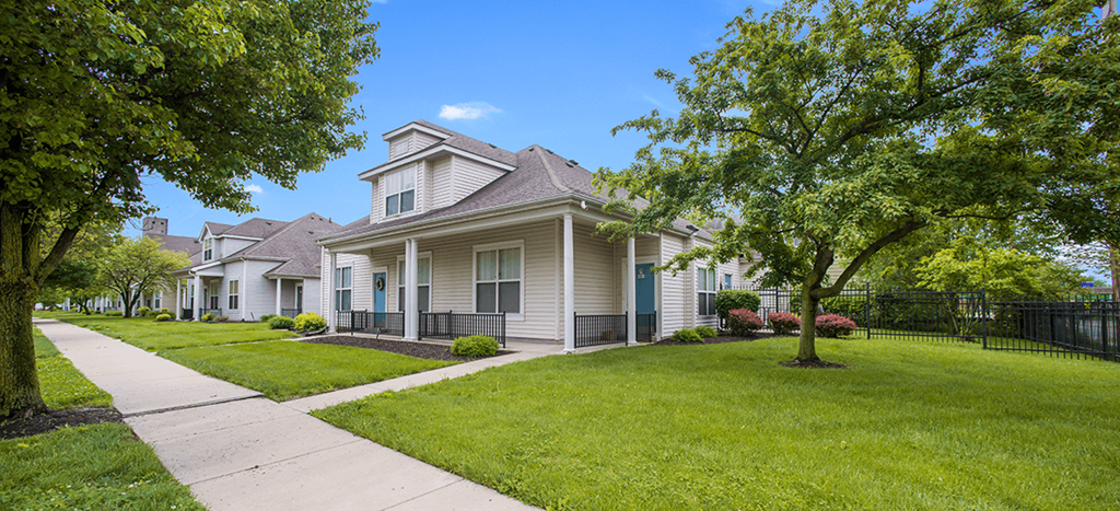 a white apartment home with a sidewalk in front of it at Parsons Place Apartments