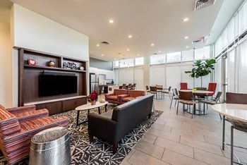 A living room with a black couch and a television.