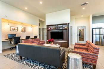A living room with a black couch and a television.