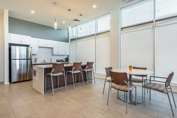 A kitchen with a table and chairs in front of a window.