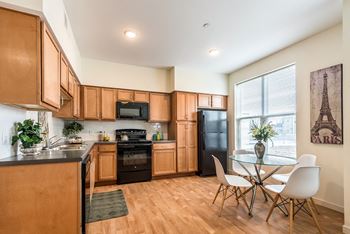A kitchen with wooden cabinets and a black refrigerator.