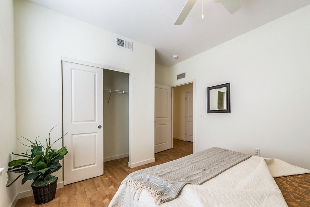 a bedroom with a large bed and a closet at Legacy Pointe at Poindexter Apartments & Townhomes
