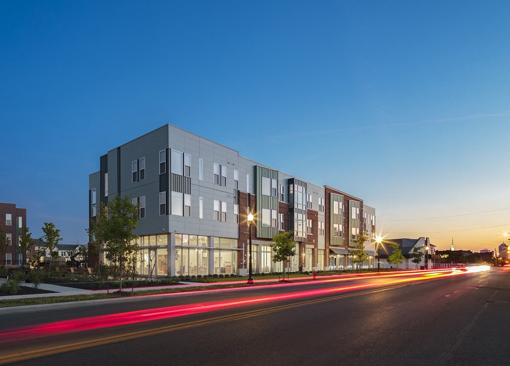 a rendering of a building on a city street at night at Legacy Pointe at Poindexter Apartments & Townhomes