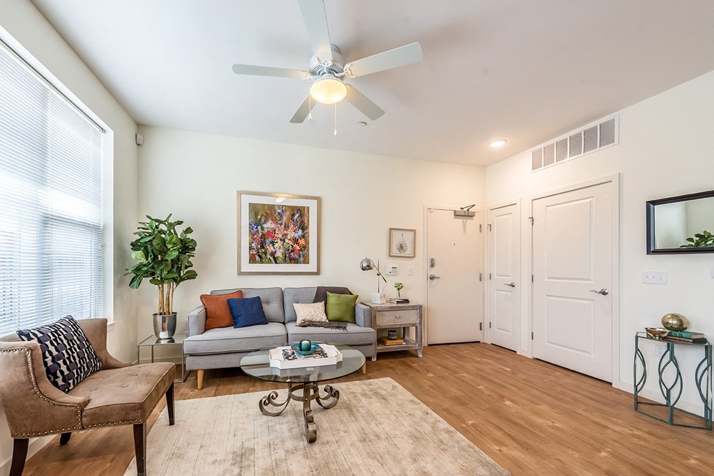 a living room with a couch and a ceiling fan at Legacy Pointe at Poindexter Apartments & Townhomes