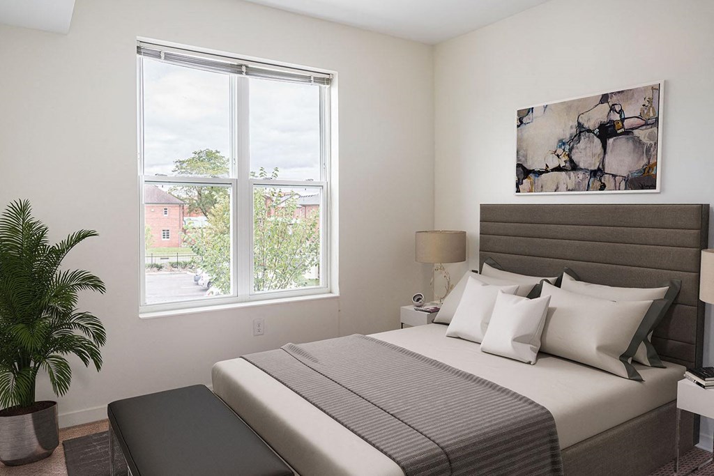 a bedroom with a bed and a window at Legacy Pointe at Poindexter Apartments & Townhomes