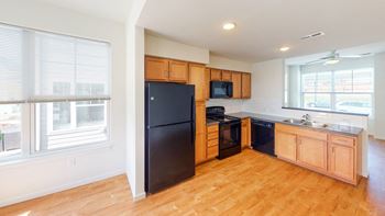 A kitchen with black appliances and wooden cabinets.