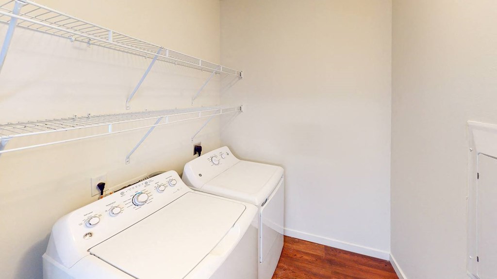 a laundry room with two washes and a dryer in it at Legacy Pointe at Poindexter Apartments & Townhomes