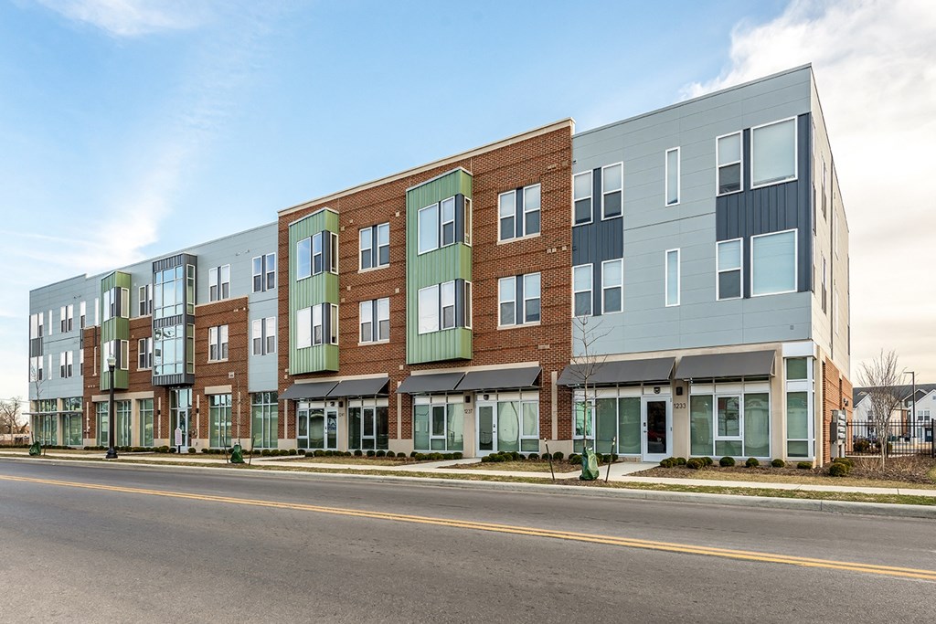 a new apartment building on the side of a street at Legacy Pointe at Poindexter Apartments & Townhomes