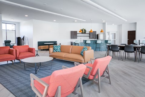 A modern living room with a grey carpet and a variety of seating options.