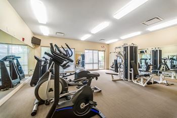 a gym with cardio equipment and weights at the renaissance at port royal apartments