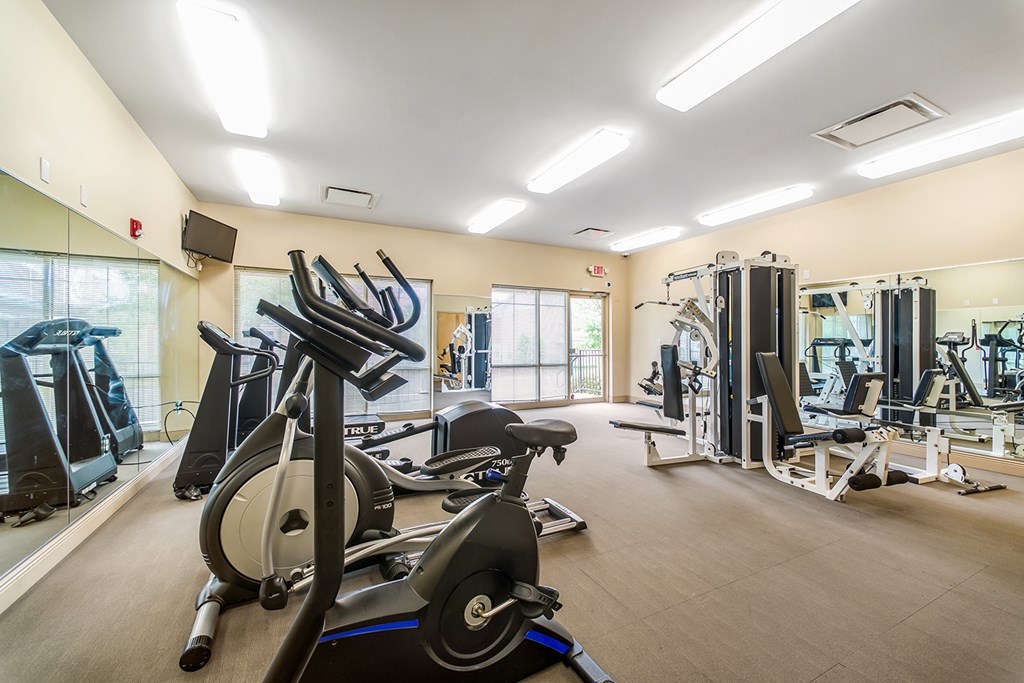 a gym with cardio equipment and weights at the renaissance at port royal apartments at Renaissance Place at Grand Apartments & Townhomes