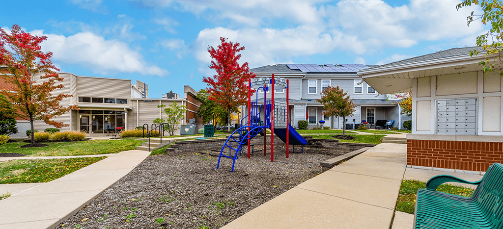 a playground in a courtyard in front of apartments at Renaissance Place at Grand Apartments