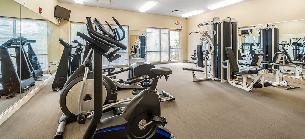 a gym with cardio equipment and weights at the at Renaissance Place at Grand Apartments