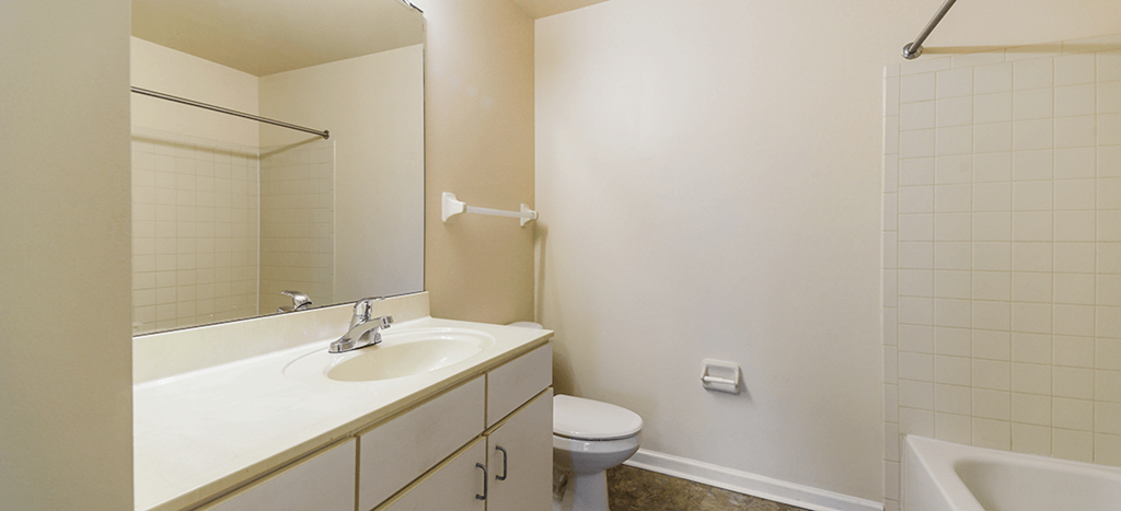 a bathroom with a sink toilet and a mirror at Renaissance Place at Grand Apartments