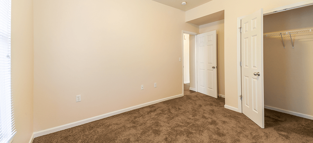 an empty bedroom with a closet at Renaissance Place at Grand Apartments