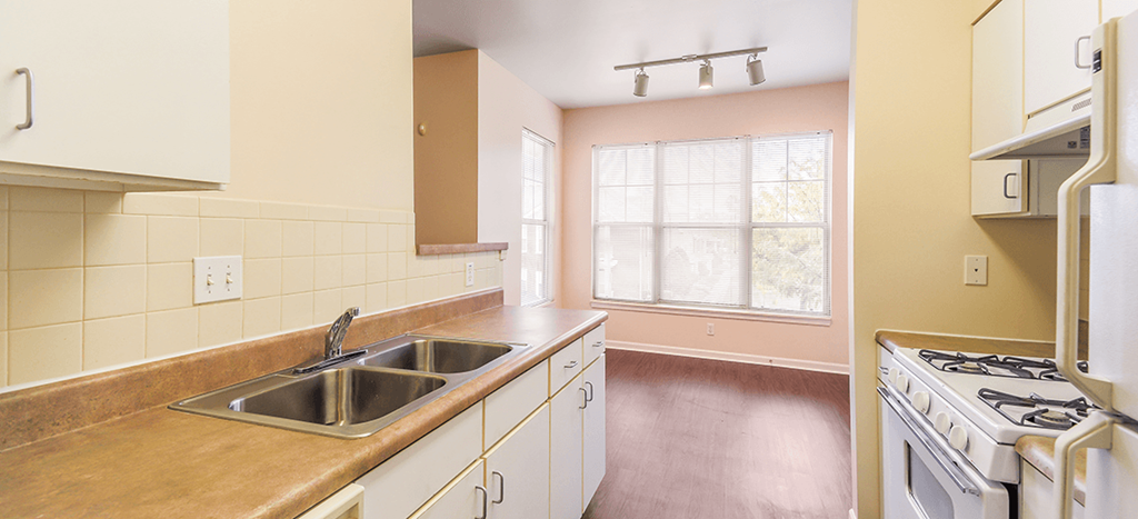 a kitchen with a sink and a stove and a window at Renaissance Place at Grand Apartments