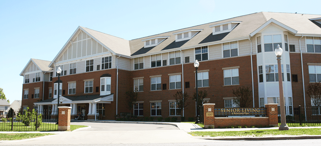 a large brick building with a sign in front of it for Senior Living at Renaissance Place