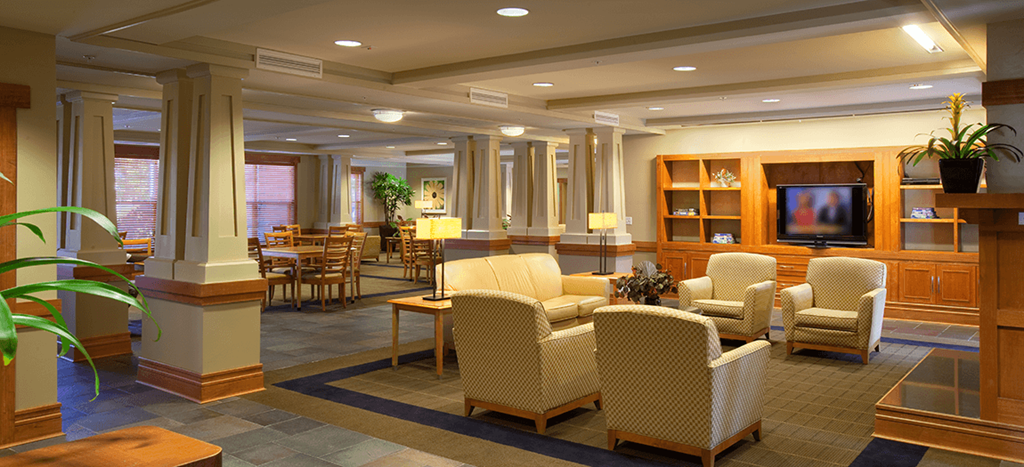Senior Living at Renaissance Place clubhouse chairs and tables and a television