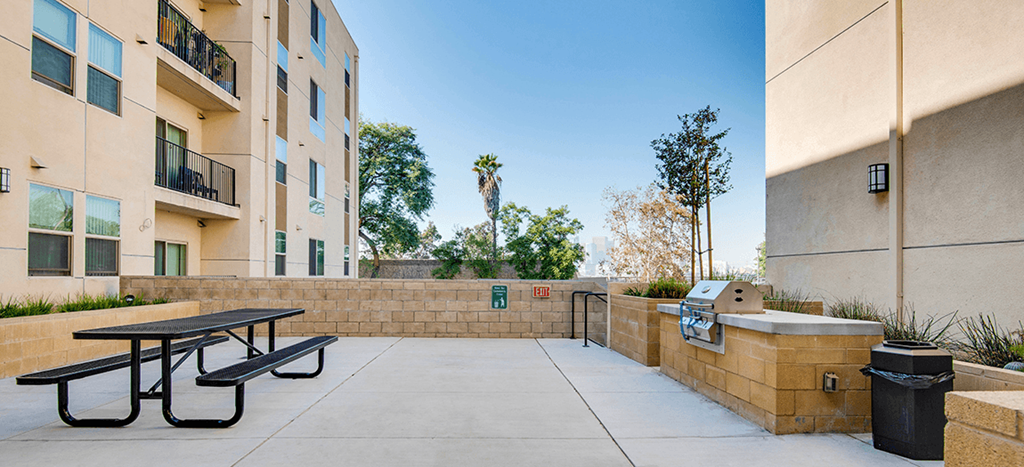 BBQ area at Santa Cecilia Apartments with a picnic table and propane grill