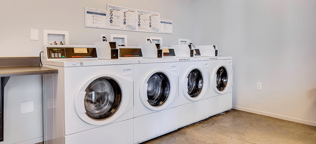 a row of washing machines in a laundry room at Santa Cecilia Apartments