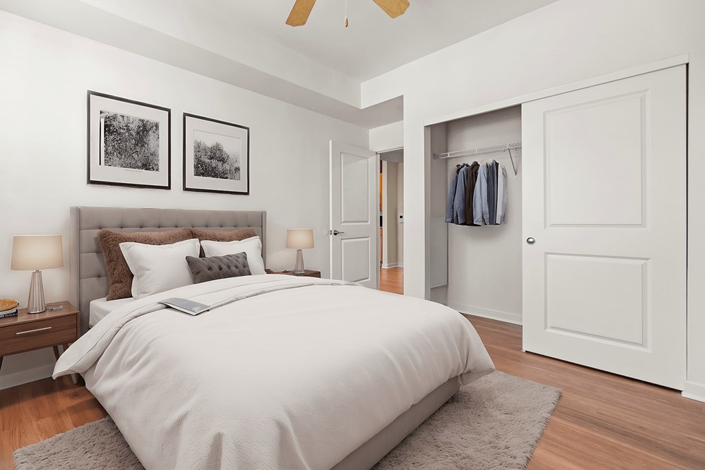 A bedroom with a large bed and a ceiling fan.