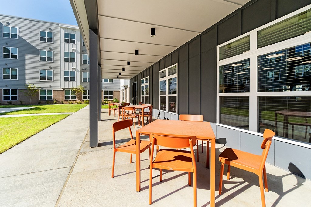a patio with tables and chairs outside of a building at South City Senior in Memphis, TN