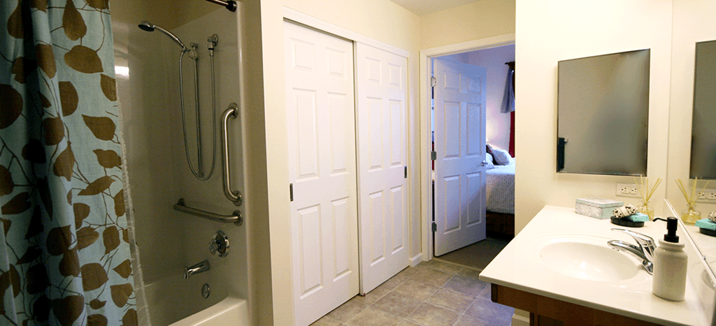 a bathroom at Cambridge Sr. with a shower and a sink and a mirror