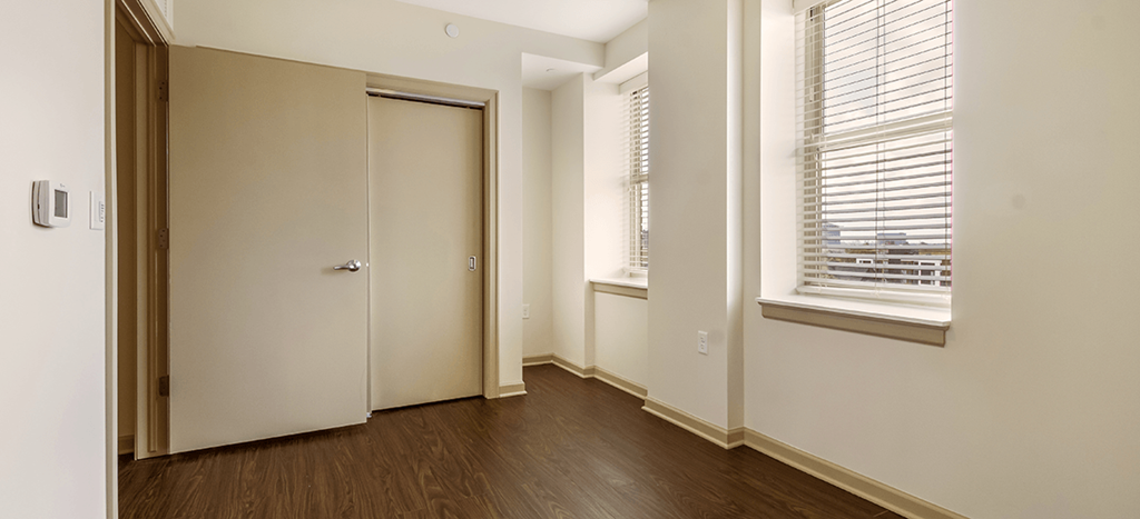 a bedroom with a door and a window and a wood floor