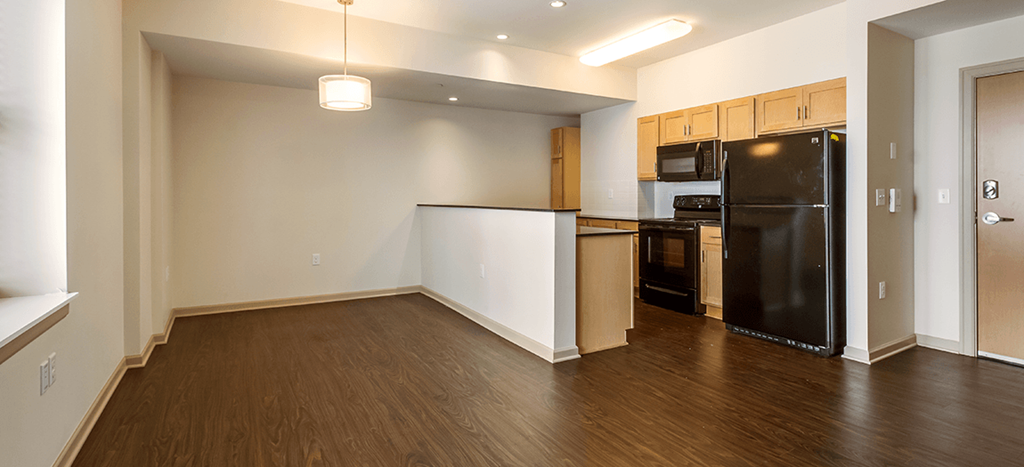 an empty kitchen with black appliances at The Strathmore Apartments