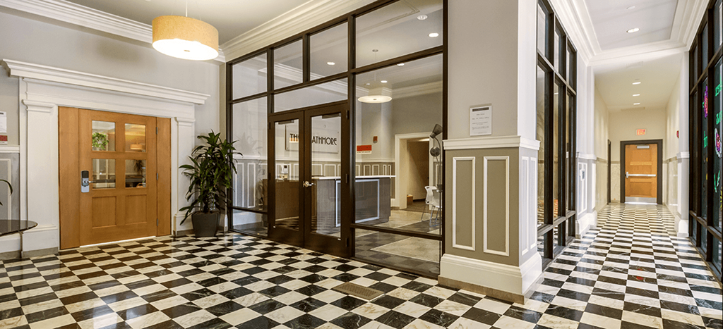 a lobby with a checkered floor and glass doors at The Strathmore Apartments