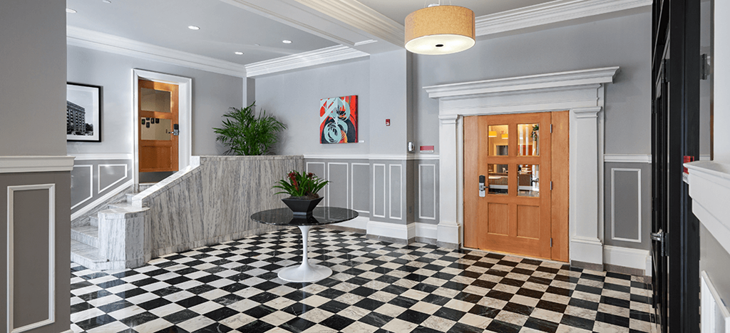 a lobby with a checkered floor and a wooden door at The Strathmore Apartments