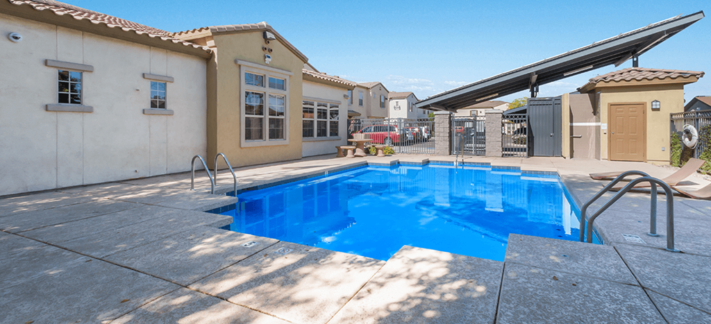 a swimming pool in front of the Symphony apartments clubhouse