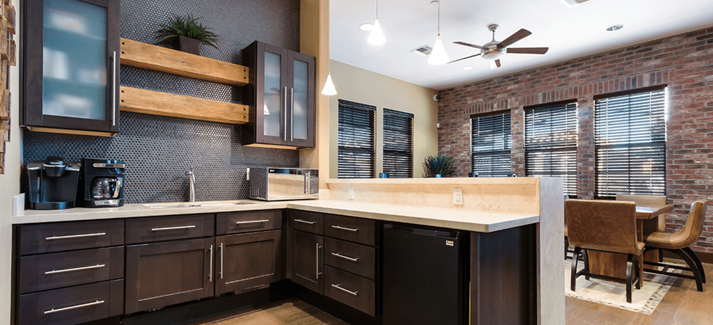 Clubhouse kitchen with a large counter top and a window at The Symphony Apartments