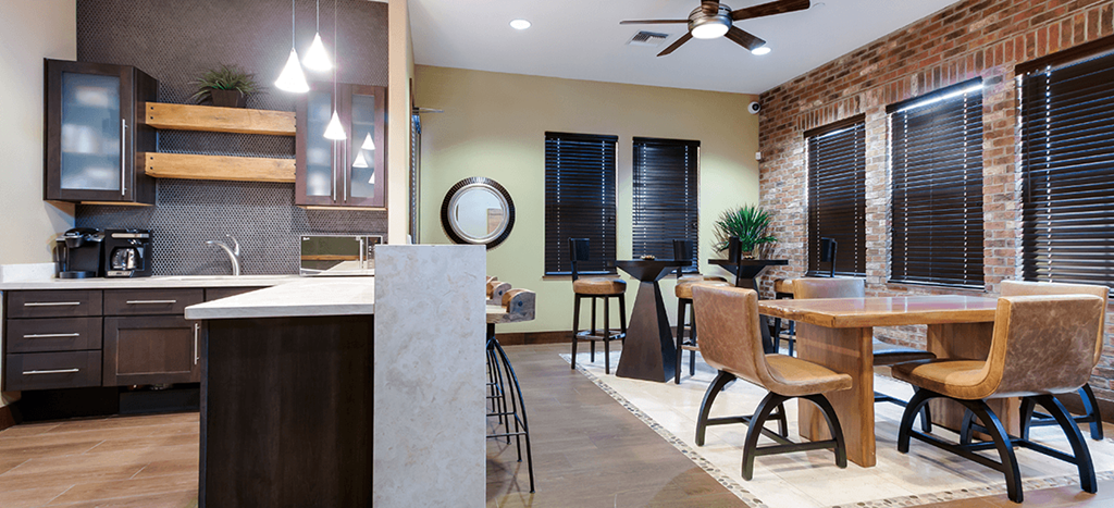 Symphony apartments clubhouse with a kitchen with a bar with a table and chairs