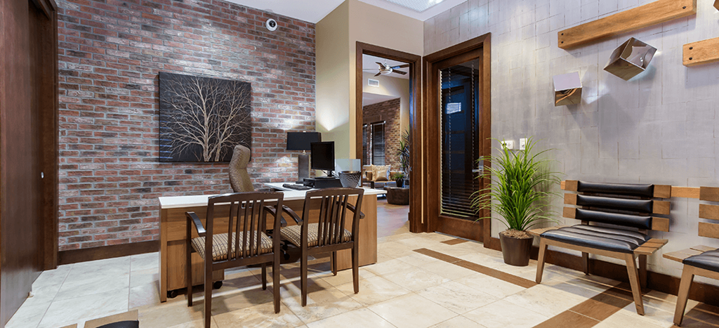 The Symphony Apartments clubhouse with a table and chairs and a brick wall