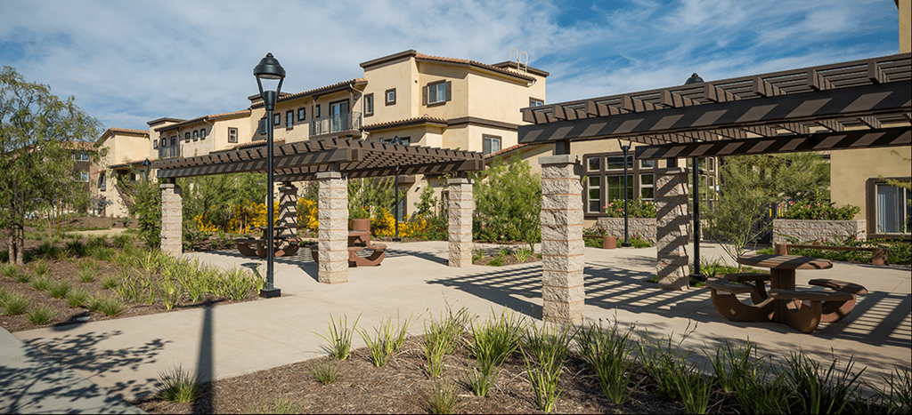 a patio with a picnic table and a building in the background at Taylor Yard Apartments