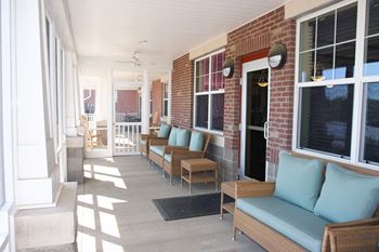 a porch with furniture and a brick wall at University Place Senior