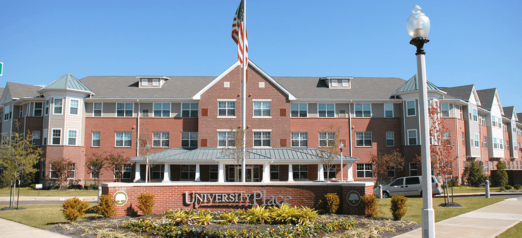 Senior Living at University Place apartment building with an flag in front of it