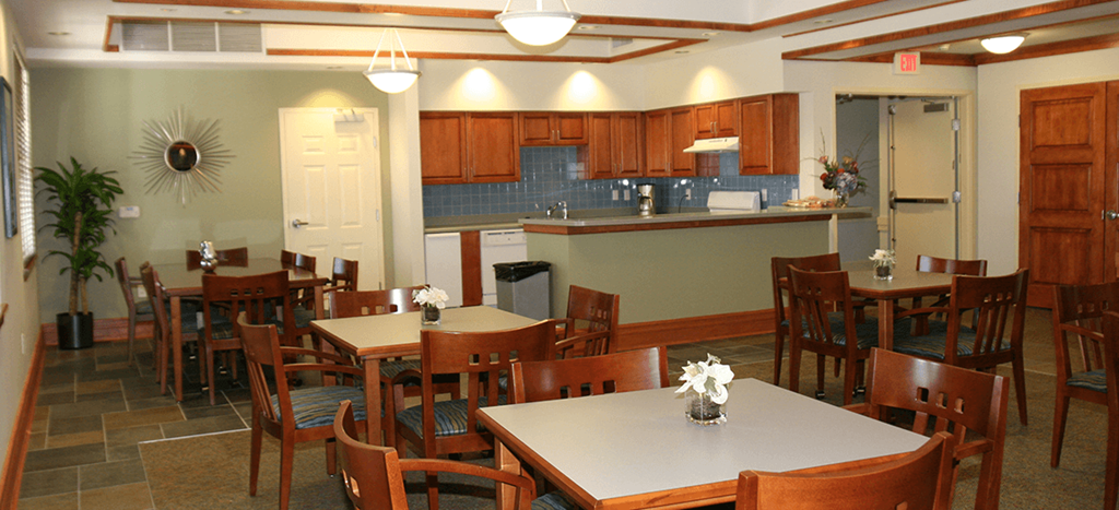 Clubhouse at Senior Living at University Place with tables and chairs and a kitchen