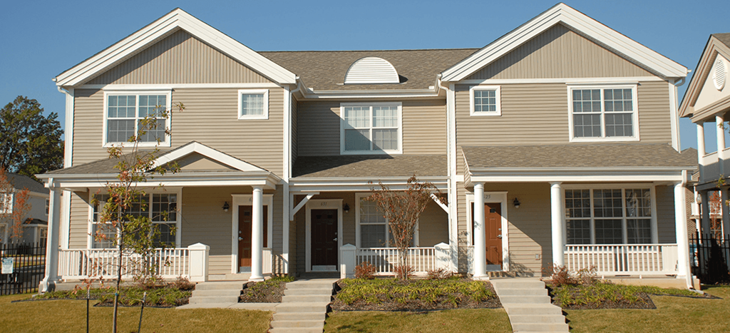 a large townhome with a porch and a yard at University Place Apartments