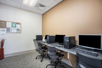a computer room with monitors and computers on a table