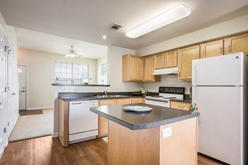 a kitchen with white appliances and wooden cabinets