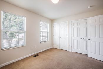 an empty living room with two doors and a window
