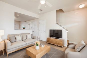 a living room with couches and a coffee table and a television