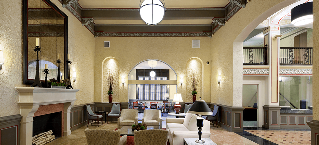 Clubhouse a lobby with couches and chairs and a fireplace at Valentine Apartments