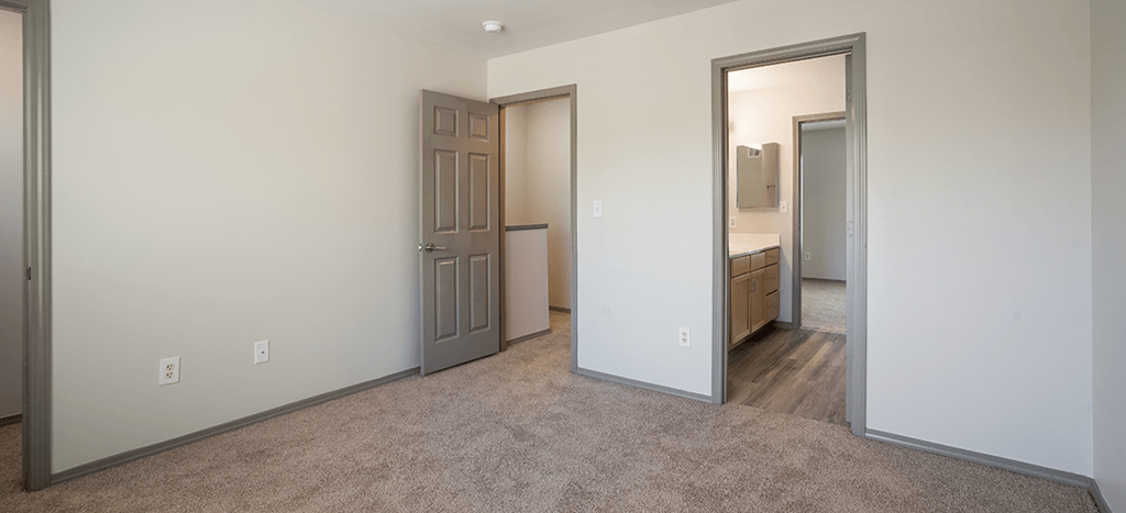 a bedroom with a closet and a door to a bathroom