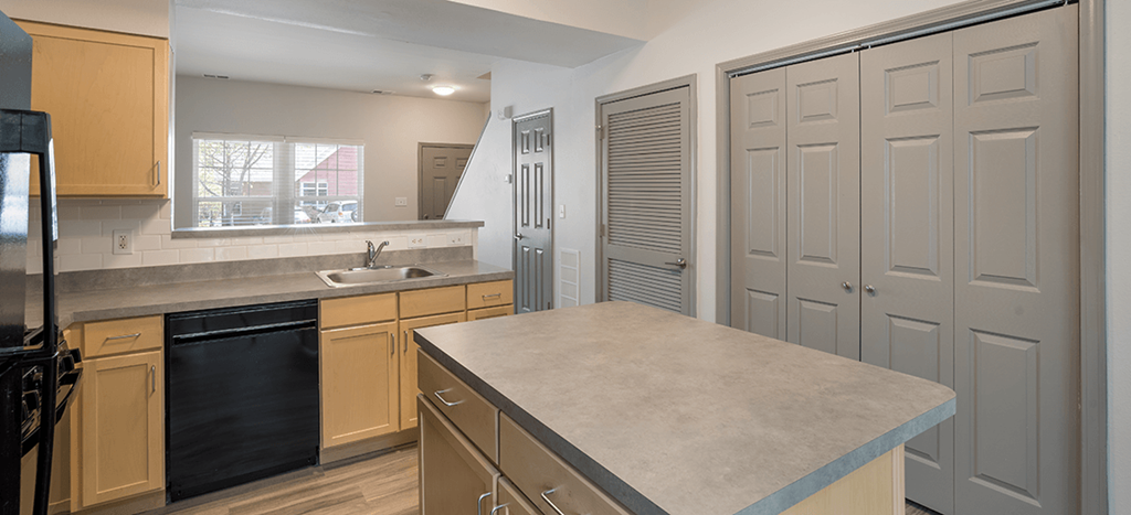a kitchen with white cabinets and black appliances and a counter top