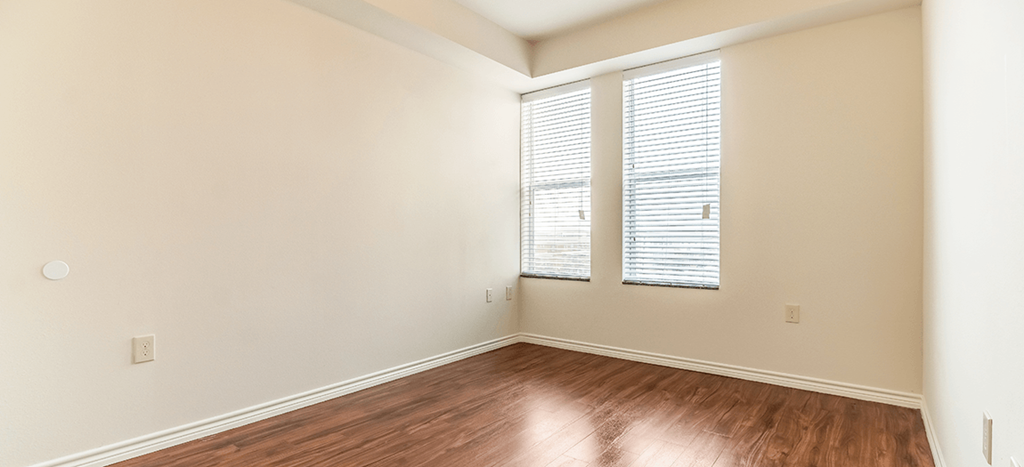 Villas on the Strand spacious bedroom with wood flooring and two windows